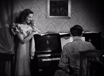 Movie still from “Paisan” (1946), directed by Roberto Rossellini – An old photo of a woman and a man at a piano; Medium shot, High angle