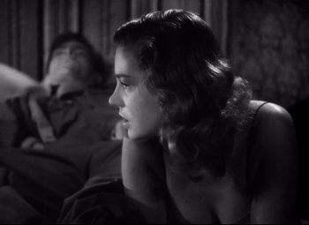 Movie still from “Paisan” (1946), directed by Roberto Rossellini – A woman sitting on a couch with her head resting on her hand; Close Up shot, Low angle