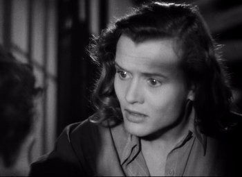 Movie still from “Paisan” (1946), directed by Roberto Rossellini – A black - and - white photo of a man with long hair; Close Up shot, High angle