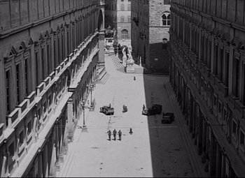 Movie still from “Paisan” (1946), directed by Roberto Rossellini – A black - and - white photo of people walking down a street; Extreme Wide shot, High angle
