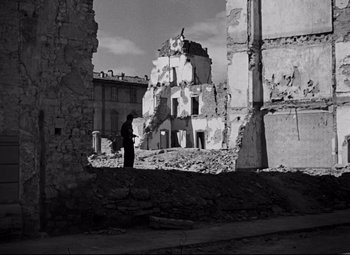 Movie still from “Paisan” (1946), directed by Roberto Rossellini – A man standing in front of an old ruined building; Wide shot, Low angle