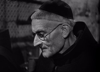 Movie still from “Paisan” (1946), directed by Roberto Rossellini – An old man wearing glasses and a hat; Close Up shot, High angle