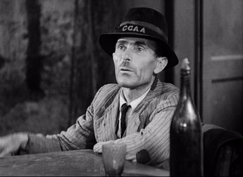Movie still from “Paisan” (1946), directed by Roberto Rossellini – An older man sitting at a table with a bottle of wine; Close Up shot, Low angle