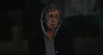 Movie still from “Palo Alto” (2013), directed by Gia Coppola – An older woman wearing glasses and a hooded jacket; Close Up shot, Over the shoulder angle