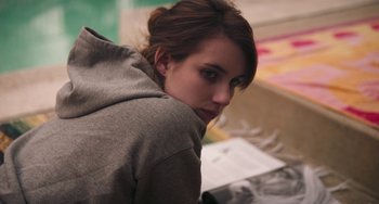 Movie still from “Palo Alto” (2013), directed by Gia Coppola – A young woman in a gray hoodie is looking at the camera; Close Up shot, Over the shoulder angle