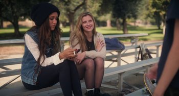 Movie still from “Palo Alto” (2013), directed by Gia Coppola – Two young women sitting on a park bench looking at a cell phone; Medium shot, Over the shoulder angle