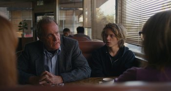 Movie still from “Palo Alto” (2013), directed by Gia Coppola – An older man and a younger man sitting at a table; Medium shot, Over the shoulder angle