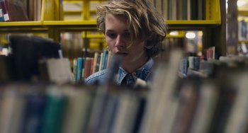 Movie still from “Palo Alto” (2013), directed by Gia Coppola – A man sitting in front of a book shelf in a library; Close Up shot, Over the shoulder angle