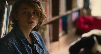 Movie still from “Palo Alto” (2013), directed by Gia Coppola – A young man is sitting in front of a bookshelf; Close Up shot, Over the shoulder angle