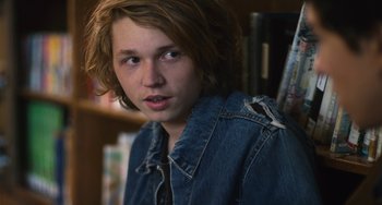 Movie still from “Palo Alto” (2013), directed by Gia Coppola – A young man in a denim jacket looking at the camera; Close Up shot, Over the shoulder angle