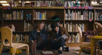 Movie still from “Palo Alto” (2013), directed by Gia Coppola – Two young men sitting on the floor in front of bookshelves; Medium shot, Low angle