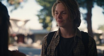 Movie still from “Palo Alto” (2013), directed by Gia Coppola – A man with long blonde hair wearing a plaid shirt; Close Up shot, Over the shoulder angle