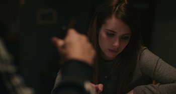 Movie still from “Palo Alto” (2013), directed by Gia Coppola – A woman sitting in front of a man with her hand raised; Close Up shot, Over the shoulder angle