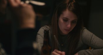 Movie still from “Palo Alto” (2013), directed by Gia Coppola – A woman sitting at a table with a bottle of beer; Close Up shot, High angle