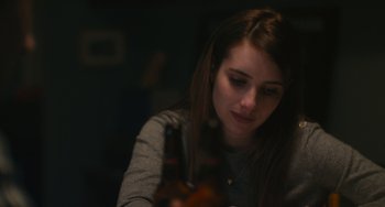 Movie still from “Palo Alto” (2013), directed by Gia Coppola – A woman sitting at a table with a bottle of beer in front of her; Close Up shot, High angle