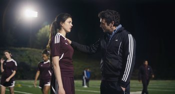 Movie still from “Palo Alto” (2013), directed by Gia Coppola – A man and a woman standing next to each other on a soccer field; Medium shot, Over the shoulder angle