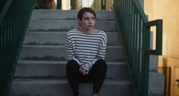 Movie still from “Palo Alto” (2013), directed by Gia Coppola – A woman sitting on the steps of a building looking sad; Medium shot, High angle