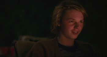Movie still from “Palo Alto” (2013), directed by Gia Coppola – A young man sitting in front of a dark background; Close Up shot, Over the shoulder angle