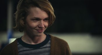 Movie still from “Palo Alto” (2013), directed by Gia Coppola – A young man with long blonde hair wearing a striped shirt; Close Up shot, Over the shoulder angle