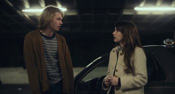 Movie still from “Palo Alto” (2013), directed by Gia Coppola – A man and a woman standing next to each other in front of a car; Medium shot, Over the shoulder angle
