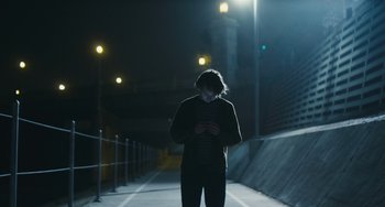 Movie still from “Palo Alto” (2013), directed by Gia Coppola – A man standing in a dark alley at night; Wide shot, Low angle
