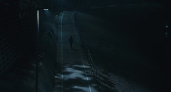 Movie still from “Palo Alto” (2013), directed by Gia Coppola – A person walking down a street at night; Extreme Wide shot, High angle