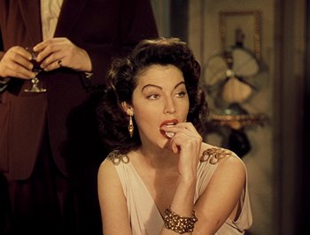 Movie still from “Pandora and the Flying Dutchman” (1951), directed by Albert Lewin – A woman sitting down with her hand in her mouth; Close Up shot, Over the shoulder angle