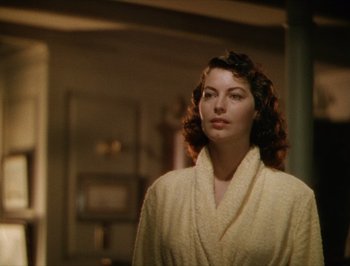 Movie still from “Pandora and the Flying Dutchman” (1951), directed by Albert Lewin – A woman in a white bathrobe standing in front of a mirror; Close Up shot, Over the shoulder angle