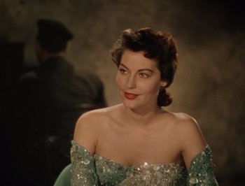 Movie still from “Pandora and the Flying Dutchman” (1951), directed by Albert Lewin – A woman in a green dress sitting in front of a wall; Close Up shot, Over the shoulder angle