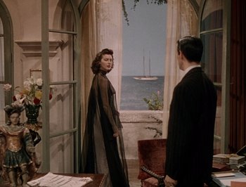 Movie still from “Pandora and the Flying Dutchman” (1951), directed by Albert Lewin – A man and a woman standing in front of a window; Wide shot, Over the shoulder angle