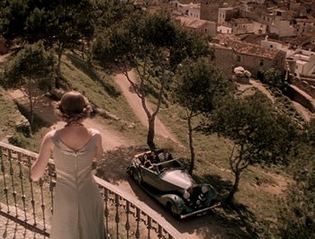 Movie still from “Pandora and the Flying Dutchman” (1951), directed by Albert Lewin – A woman standing on a railing looking at a car; Extreme Wide shot, High angle