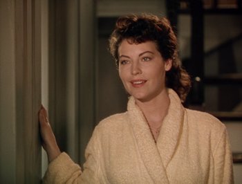 Movie still from “Pandora and the Flying Dutchman” (1951), directed by Albert Lewin – A woman in a robe standing in front of a window; Medium shot, Over the shoulder angle