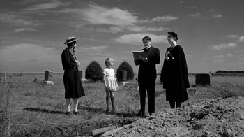 Movie still from “Paper Moon” (1973), directed by Peter Bogdanovich – A group of people standing in the grass; Wide shot, Low angle