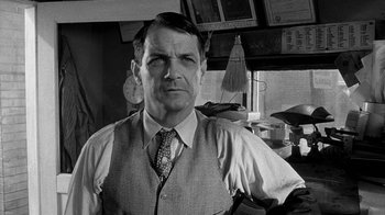 Movie still from “Paper Moon” (1973), directed by Peter Bogdanovich – Black and white photograph of a man in a restaurant; Close Up shot, Low angle