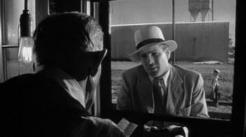 Movie still from “Paper Moon” (1973), directed by Peter Bogdanovich – A black and white photo of a man wearing a hat; Close Up shot, Over the shoulder angle