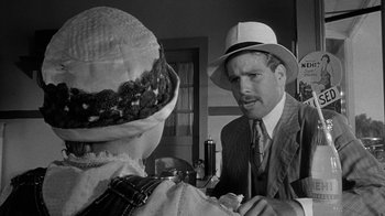Movie still from “Paper Moon” (1973), directed by Peter Bogdanovich – A man and a woman wearing hats talking to each other; Close Up shot, Over the shoulder angle
