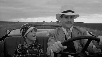 Movie still from “Paper Moon” (1973), directed by Peter Bogdanovich – A man and a boy sitting in the back seat of a car; Close Up shot, Over the shoulder angle