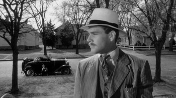 Movie still from “Paper Moon” (1973), directed by Peter Bogdanovich – A black and white photo of a man wearing a hat; Medium shot, Low angle