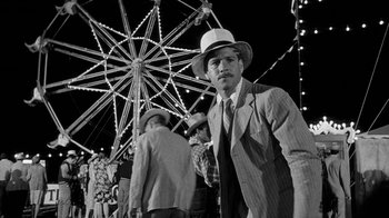 Movie still from “Paper Moon” (1973), directed by Peter Bogdanovich – A black and white photo of a man in a suit and hat; Wide shot, Low angle