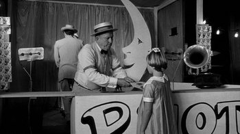 Movie still from “Paper Moon” (1973), directed by Peter Bogdanovich – A man and a little girl at a booth; Medium shot, Over the shoulder angle