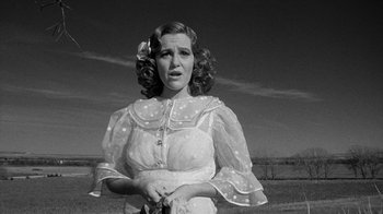 Movie still from “Paper Moon” (1973), directed by Peter Bogdanovich – An old photo of a woman in a white dress; Medium shot, Low angle