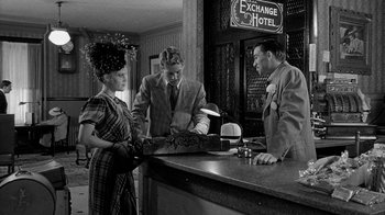 Movie still from “Paper Moon” (1973), directed by Peter Bogdanovich – A man and two women standing at a counter; Medium shot, Over the shoulder angle