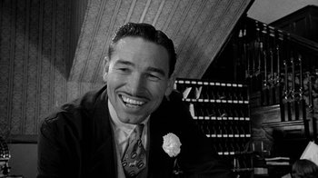 Movie still from “Paper Moon” (1973), directed by Peter Bogdanovich – A black and white photo of a man smiling; Close Up shot, Low angle