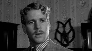 Movie still from “Paper Moon” (1973), directed by Peter Bogdanovich – A black and white photo of a man in a suit; Close Up shot, Over the shoulder angle