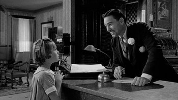 Movie still from “Paper Moon” (1973), directed by Peter Bogdanovich – A man and a boy sitting at a hotel counter; Medium shot, Over the shoulder angle