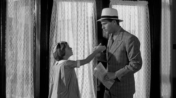 Movie still from “Paper Moon” (1973), directed by Peter Bogdanovich – A man in a suit and a woman in a hat; Medium shot, Over the shoulder angle