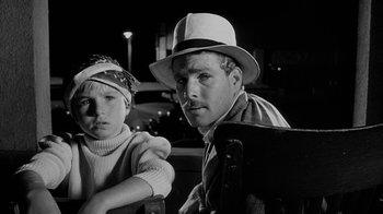 Movie still from “Paper Moon” (1973), directed by Peter Bogdanovich – A man and a woman sitting next to each other; Close Up shot, Low angle