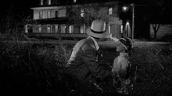 Movie still from “Paper Moon” (1973), directed by Peter Bogdanovich – A man and a boy in a field at night; Medium shot, Over the shoulder angle