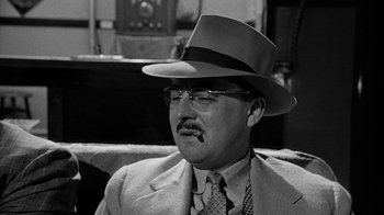 Movie still from “Paper Moon” (1973), directed by Peter Bogdanovich – An older man wearing a suit and a hat; Close Up shot, Over the shoulder angle