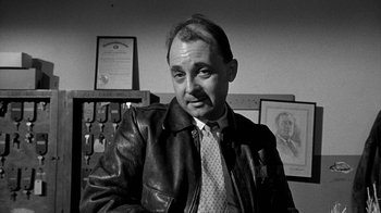 Movie still from “Paper Moon” (1973), directed by Peter Bogdanovich – An older man in a leather jacket and tie; Close Up shot, High angle